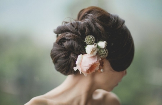 An exquisite updo, accentuated with gorgeous blossoms will add dramatic interest to an understated wedding gown. 
